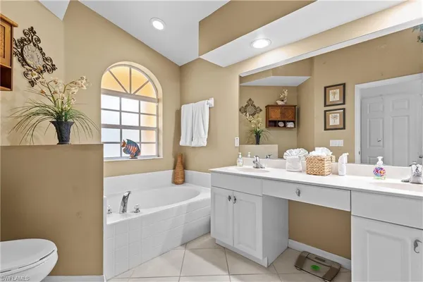 a bathroom with a bathtub sink mirror vanity and toilet