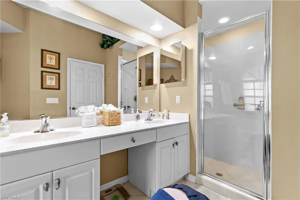 a bathroom with a double vanity sink mirror and shower