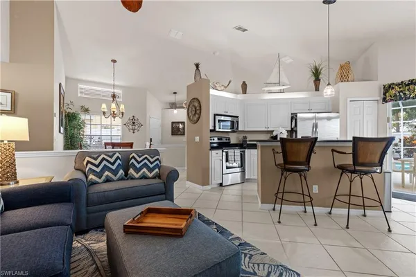 a living room with furniture and kitchen view