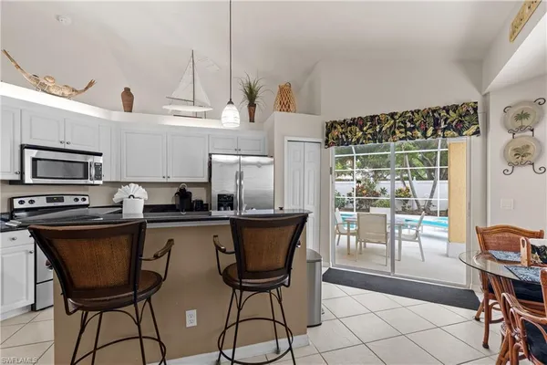 a kitchen with stainless steel appliances a table chairs and a refrigerator