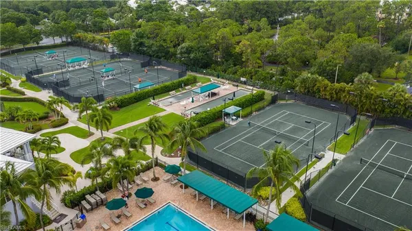 a view of a white house with a big yard and potted plants
