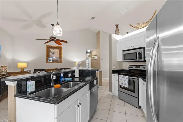 a kitchen with stainless steel appliances granite countertop a sink a stove and refrigerator
