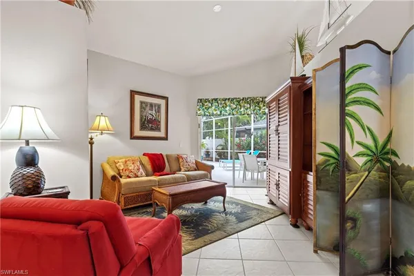 a living room with furniture a lamp and a potted plant