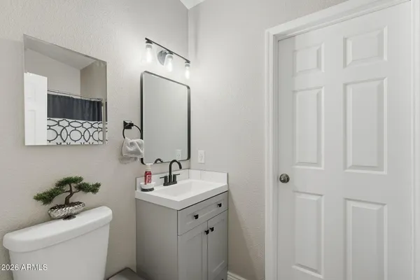 a bathroom with a toilet sink and mirror