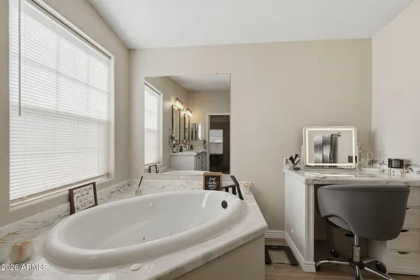 a bathroom with a tub sink and mirror