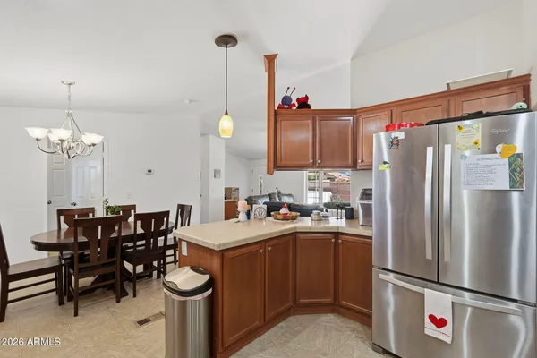 a kitchen with a refrigerator a stove a dining table and chairs