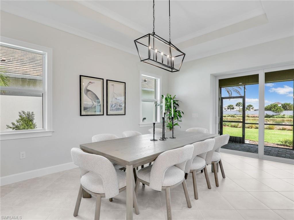 8850 Calypso Court Naples, FL 34113 - Photo 16 of 49 a view of a dining room with furniture a chandelier and wooden floor