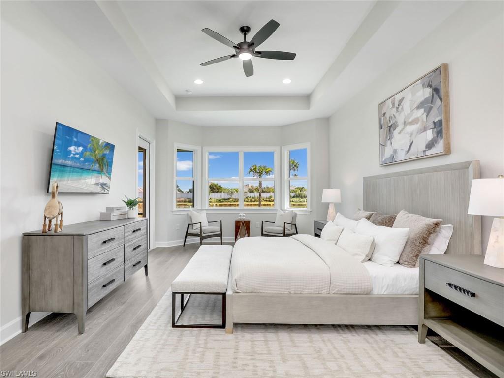 8850 Calypso Court Naples, FL 34113 - Photo 17 of 49 a bedroom with a bed and a flat screen tv