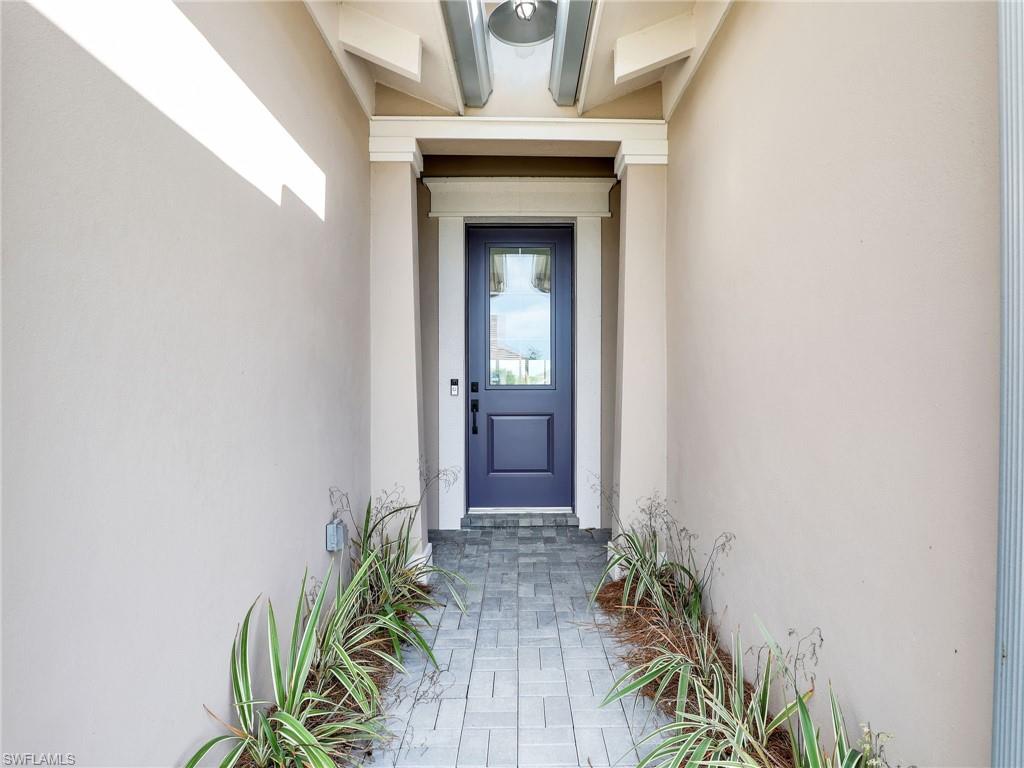 8850 Calypso Court Naples, FL 34113 - Photo 2 of 49 a front view of a house with a glass door