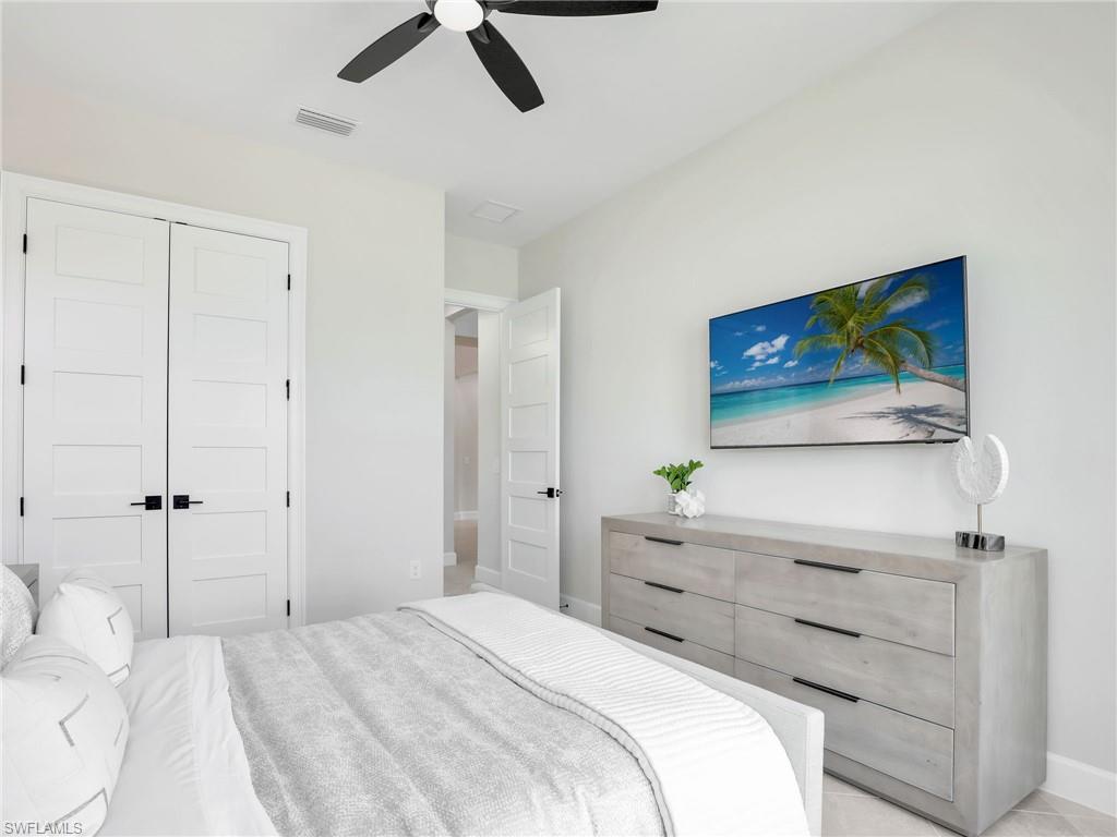 8850 Calypso Court Naples, FL 34113 - Photo 27 of 49 a bedroom with a bed and a flat screen tv