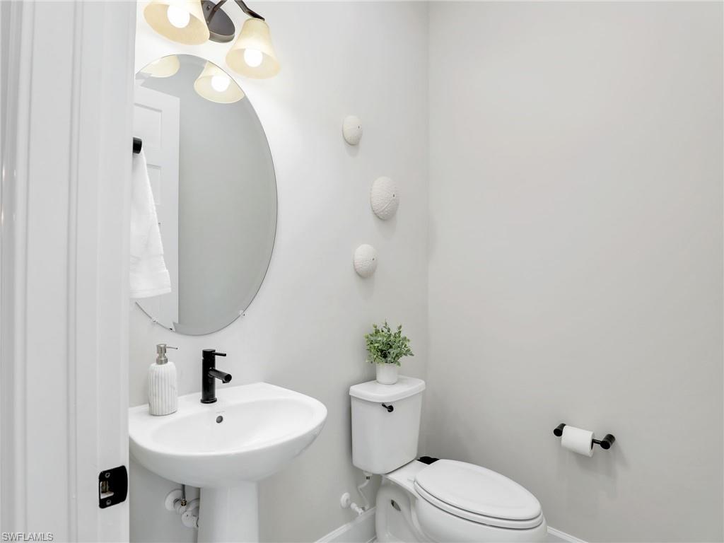 8850 Calypso Court Naples, FL 34113 - Photo 29 of 49 a bathroom with a sink a toilet and mirror