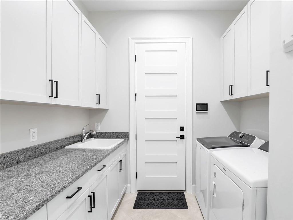 8850 Calypso Court Naples, FL 34113 - Photo 33 of 49 a kitchen with granite countertop white cabinets and white appliances