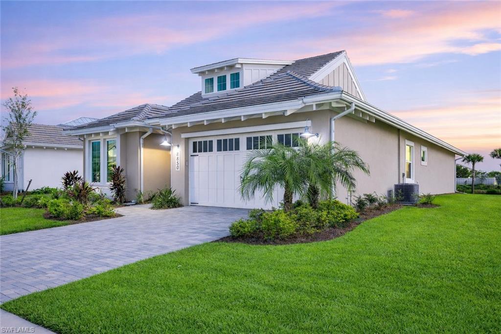8850 Calypso Court Naples, FL 34113 - Photo 39 of 49 a front view of a house with a garden