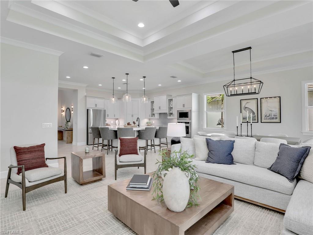 8850 Calypso Court Naples, FL 34113 - Photo 8 of 49 a living room with furniture kitchen view and a chandelier