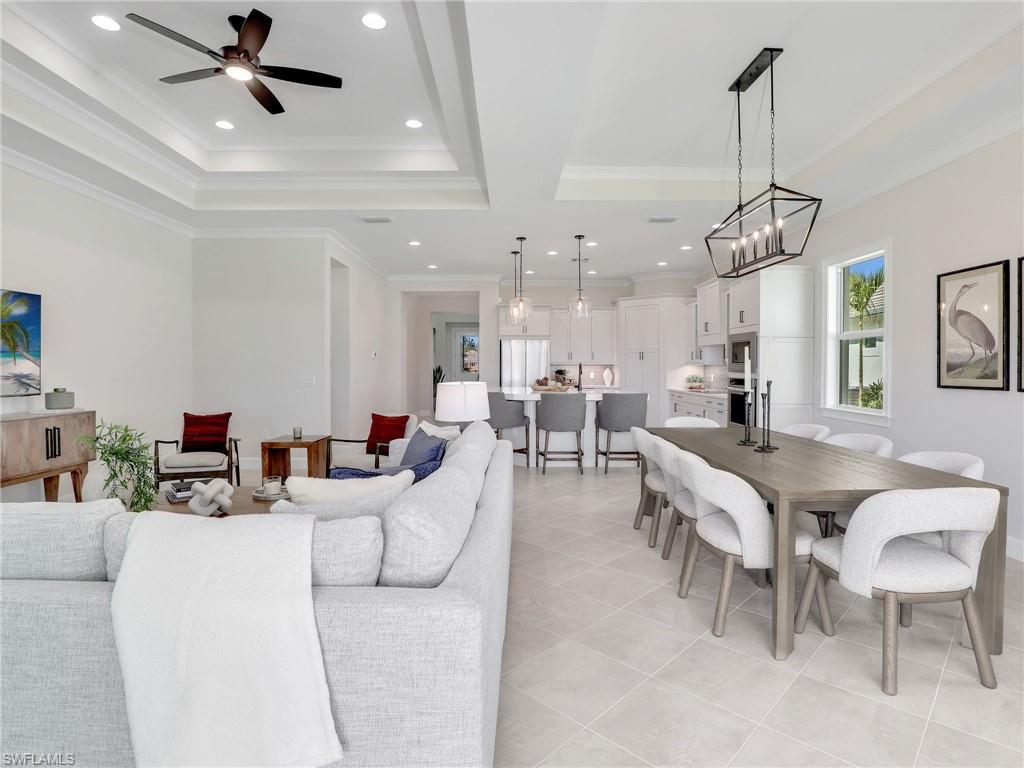8850 Calypso Court Naples, FL 34113 - Photo 9 of 49 a living room with furniture kitchen view and a chandelier