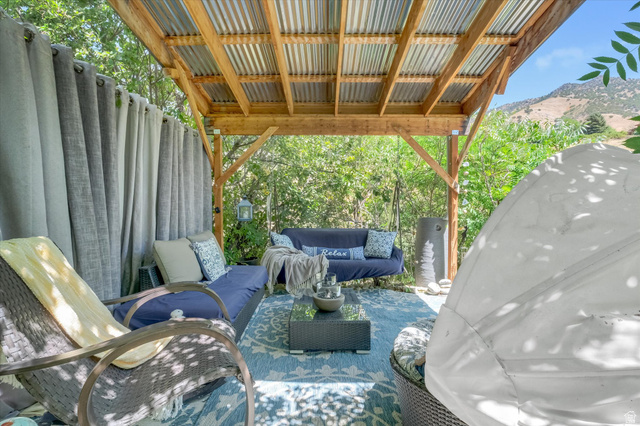 510 Spring Creek Road Providence, UT 84332 - Photo 52 of 97 Outdoor patio featuring a corrugated metal roof, exposed wood beams, and a patterned area rug
