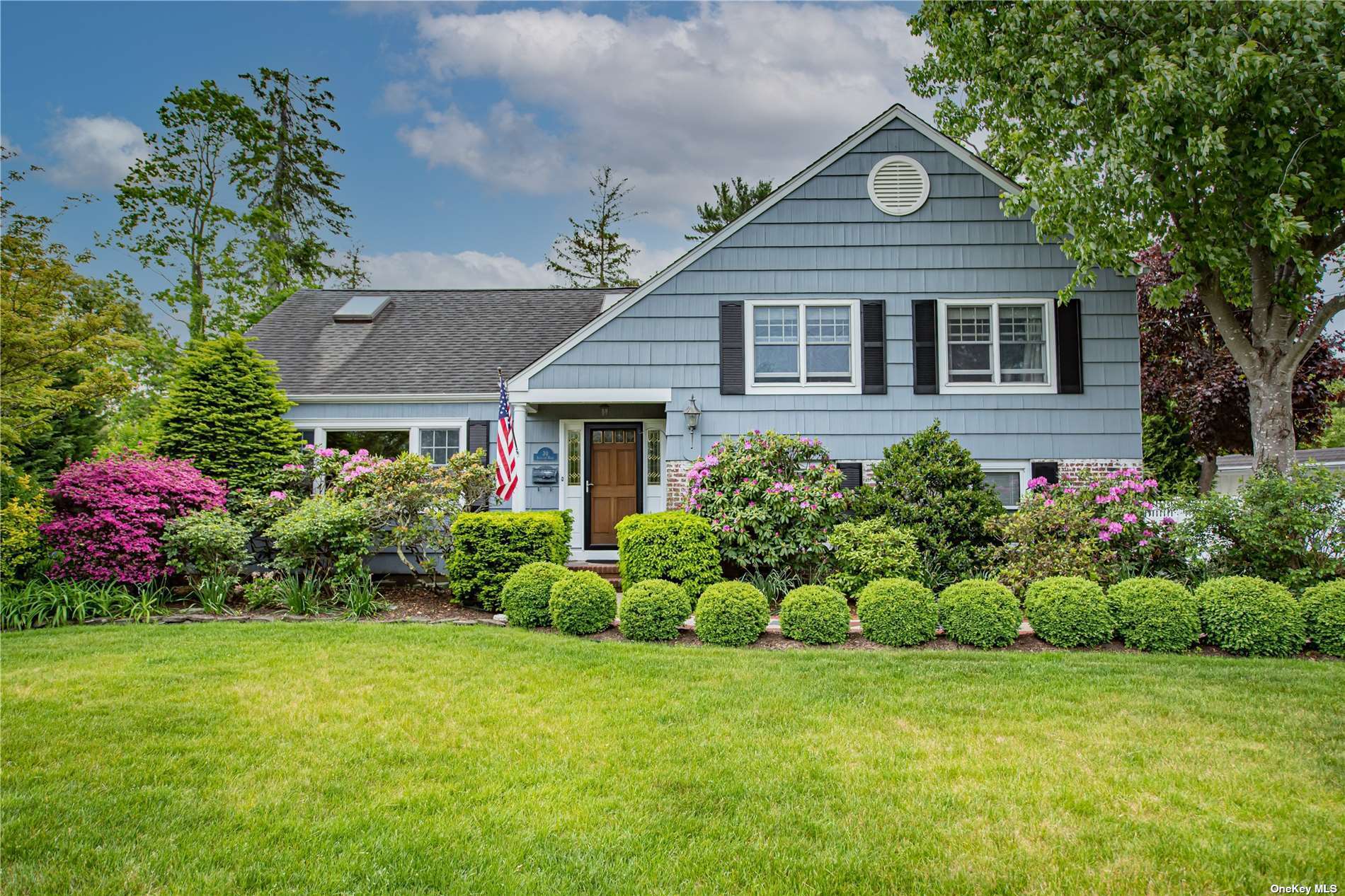 a front view of a house with a garden