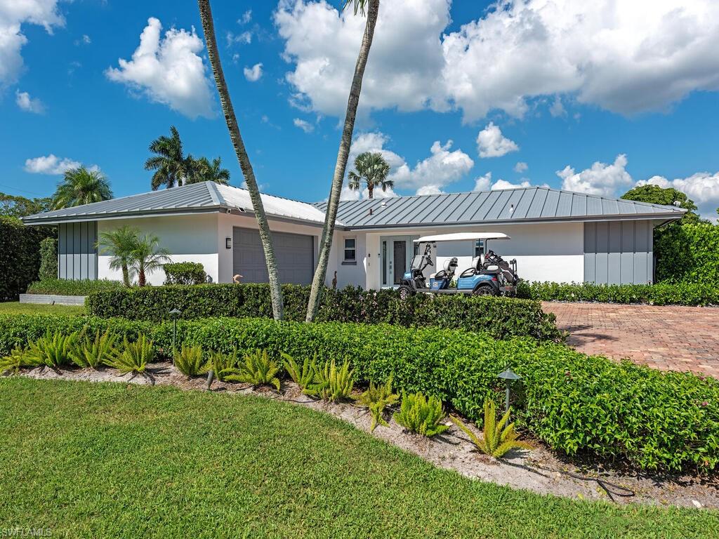 595 Wedge Drive Naples, FL 34103 - Photo 1 of 17 a front view of a house with a yard