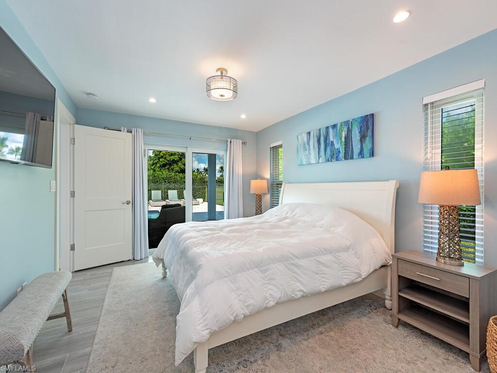 595 Wedge Drive Naples, FL 34103 - Photo 12 of 17 a bedroom with a large bed and a window