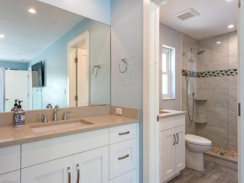 595 Wedge Drive Naples, FL 34103 - Photo 13 of 17 a bathroom with a sink a toilet and shower