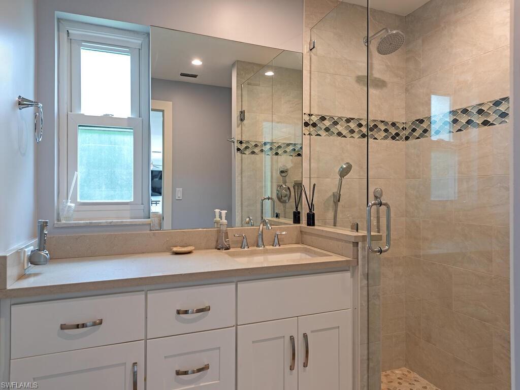 595 Wedge Drive Naples, FL 34103 - Photo 15 of 17 a bathroom with a sink and a mirror