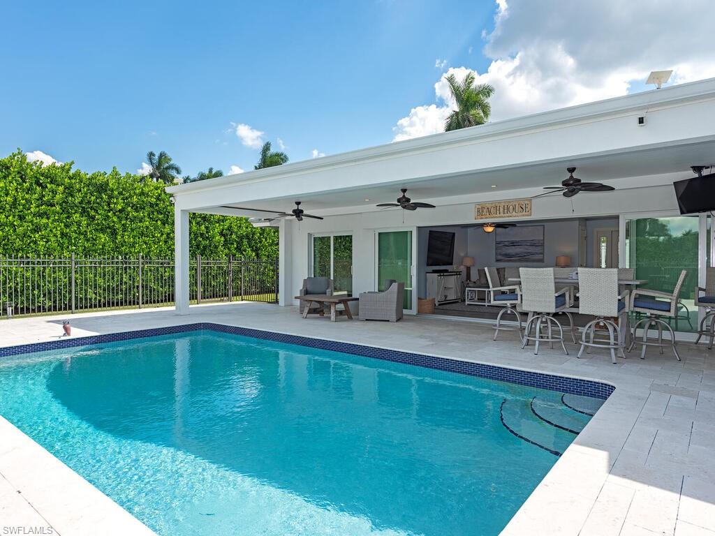 595 Wedge Drive Naples, FL 34103 - Photo 16 of 17 a view of a swimming pool with outdoor seating