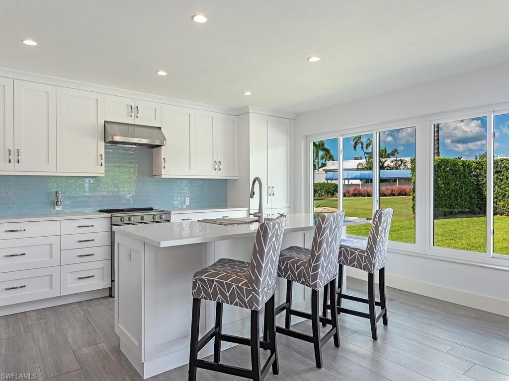 595 Wedge Drive Naples, FL 34103 - Photo 10 of 17 a kitchen with a dining table chairs and cabinets