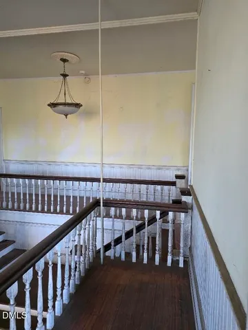 a view of staircase with railing and white wooden floor