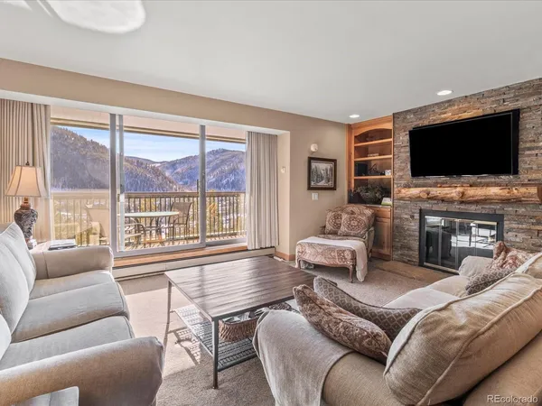 a living room with furniture a flat screen tv and a large window