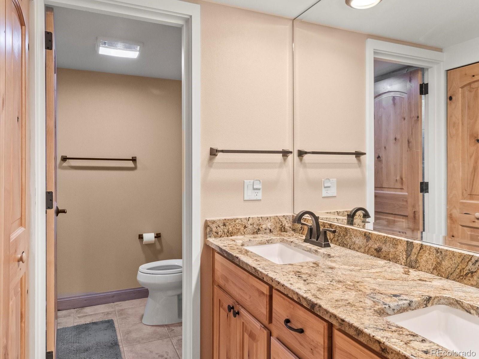 22097 Saints John Road, Unit 2540 Dillon, CO 80435 - Photo 15 of 28 a bathroom with a granite countertop sink toilet and shower