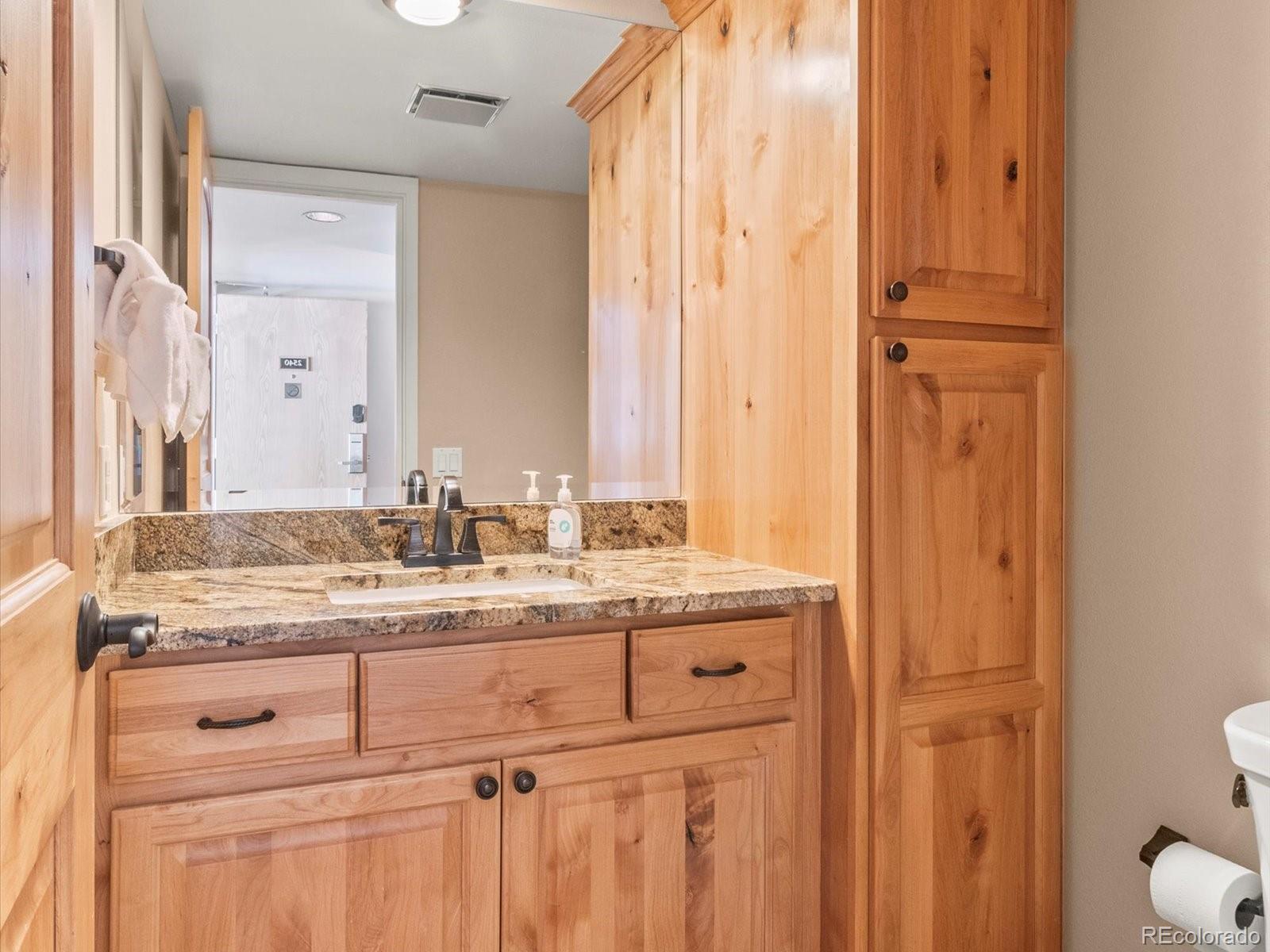 22097 Saints John Road, Unit 2540 Dillon, CO 80435 - Photo 16 of 28 a bathroom with a granite countertop sink and a mirror