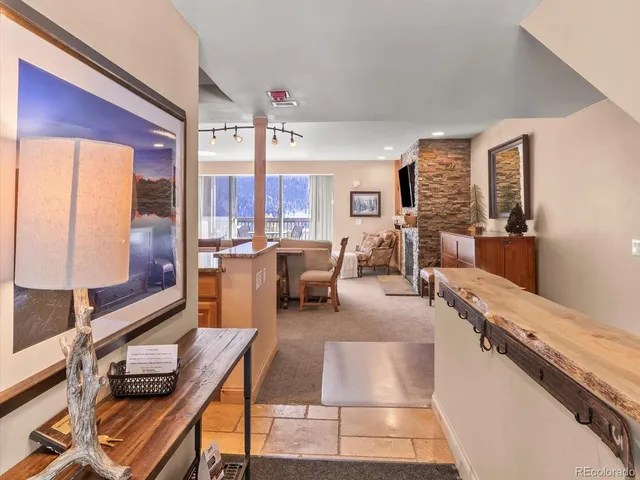 a room with stainless steel appliances kitchen island granite countertop furniture and a view of living room