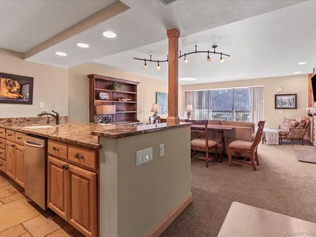 a kitchen with stainless steel appliances granite countertop sink stove and white cabinets