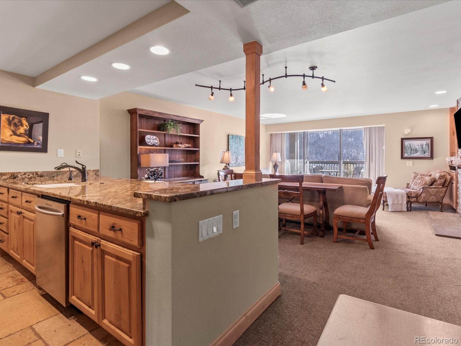 22097 Saints John Road, Unit 2540 Dillon, CO 80435 - Photo 6 of 28 a kitchen with stainless steel appliances granite countertop sink stove and white cabinets
