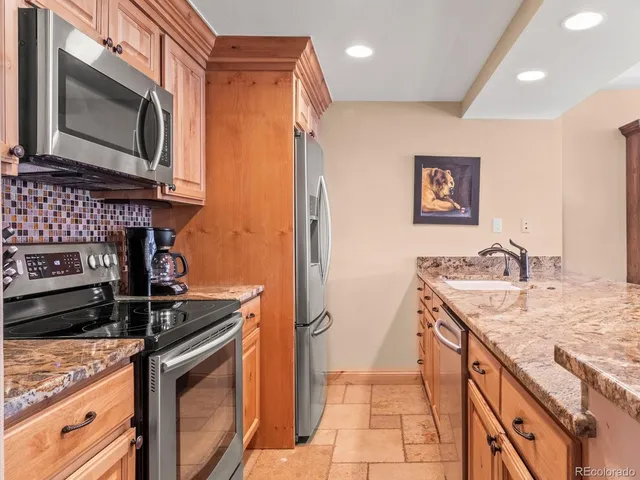 a kitchen with stainless steel appliances granite countertop a stove a sink and a microwave