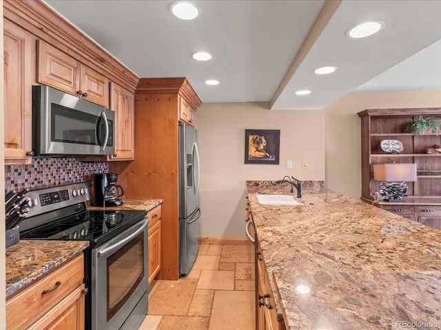 a kitchen with stainless steel appliances granite countertop a sink stove and refrigerator