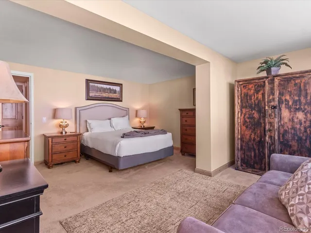 a bedroom with a bed couch and a large window