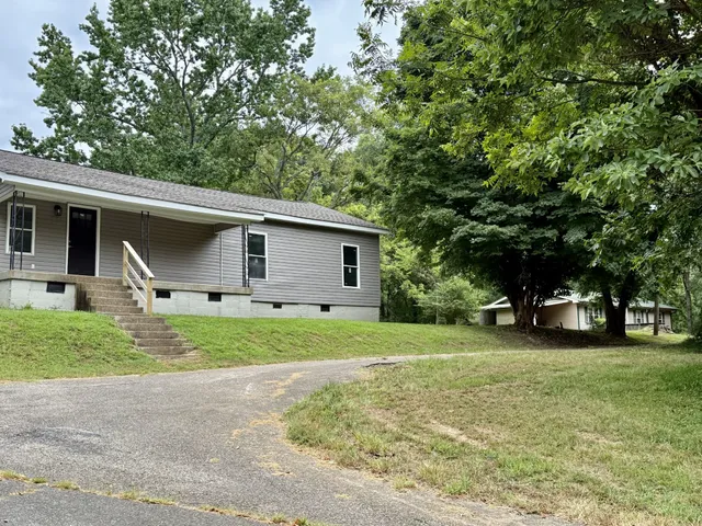 a front view of house with yard and trees