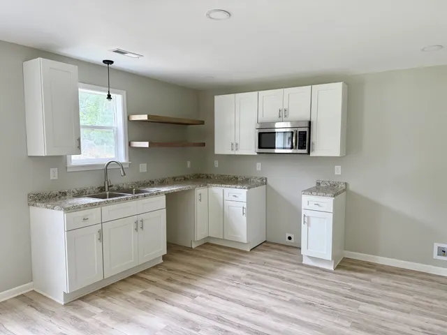 a kitchen with a sink cabinets and wooden floor