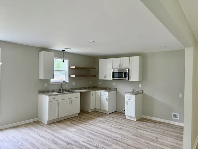 a kitchen with stainless steel appliances granite countertop a stove a sink and a microwave