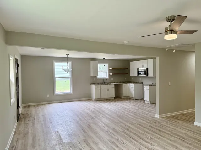 a view of kitchen with wooden floor electronic appliances and window