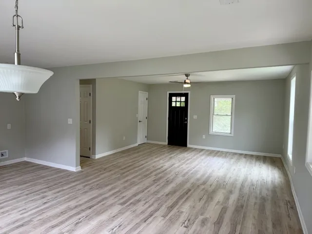 an empty room with window and wooden floor