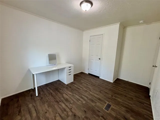 an empty room with wooden floor and window