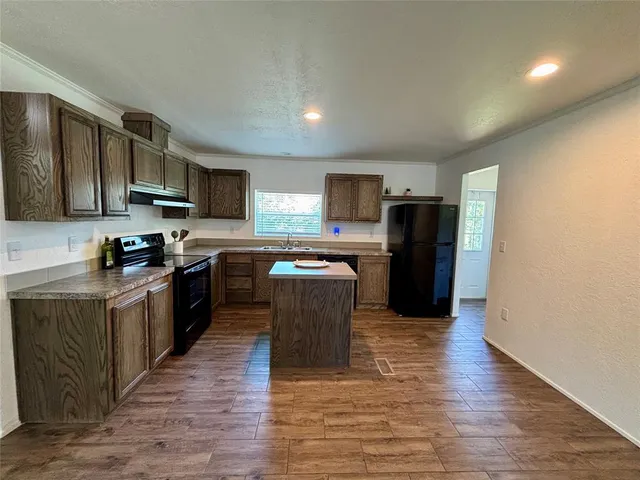 a kitchen with a refrigerator stove top oven and sink