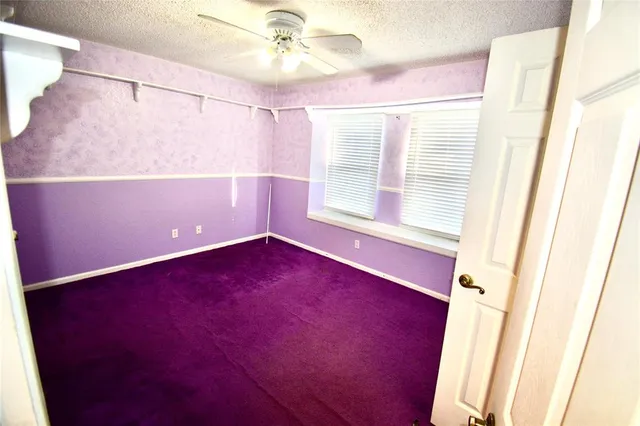 a view of a room with a ceiling fan and a window