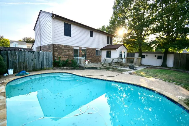 a view of a house with a small yard and large tree
