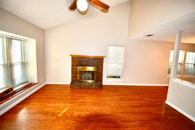 a view of a livingroom with wooden floor and a ceiling fan