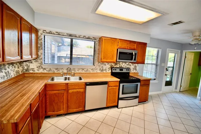 a kitchen with stainless steel appliances granite countertop a stove a sink dishwasher a refrigerator and a microwave oven