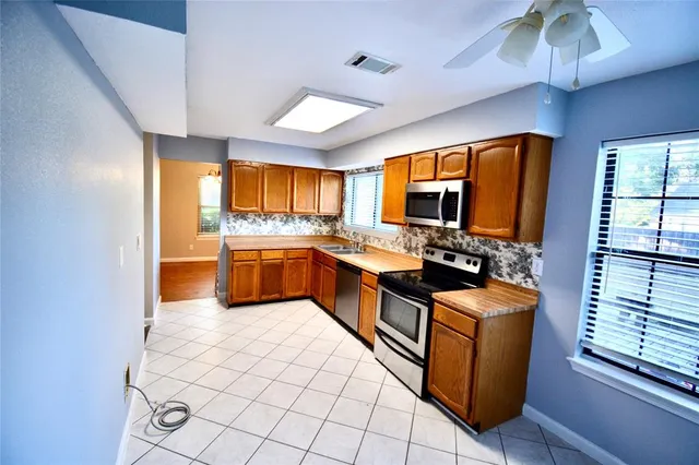 a kitchen with stainless steel appliances granite countertop a sink and a refrigerator