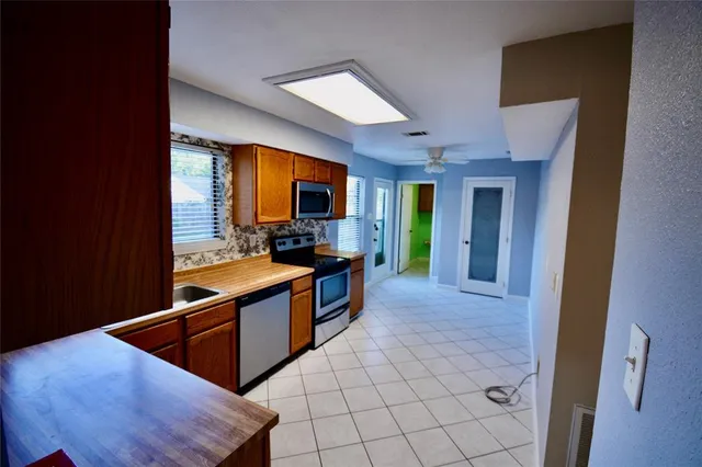 a view of a hallway with a chandelier fan and windows